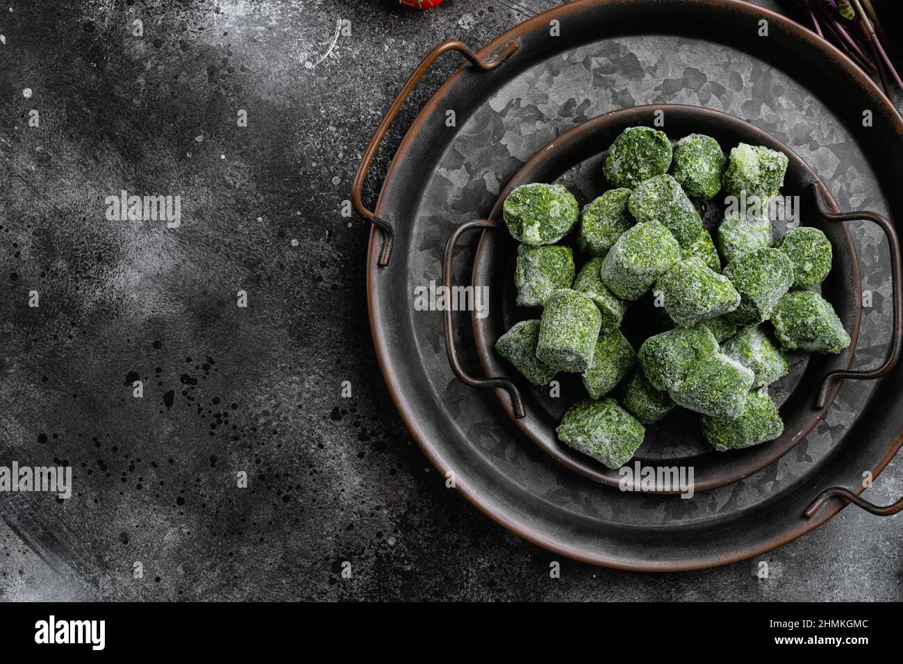Frozen spinach blocks set, on black dark stone table background, top