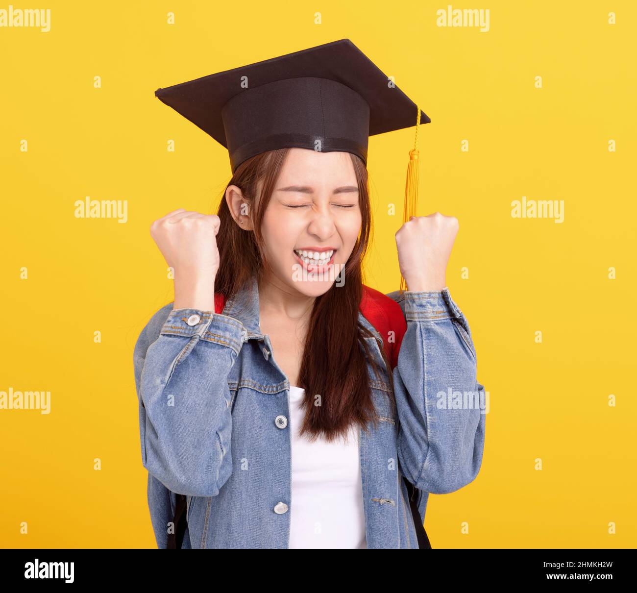 Happy Asian girl college student in Graduation cap  with success gesture Stock Photo