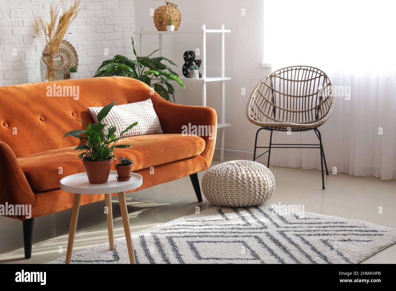 Stylish orange sofa with houseplants in modern interior of living room ...