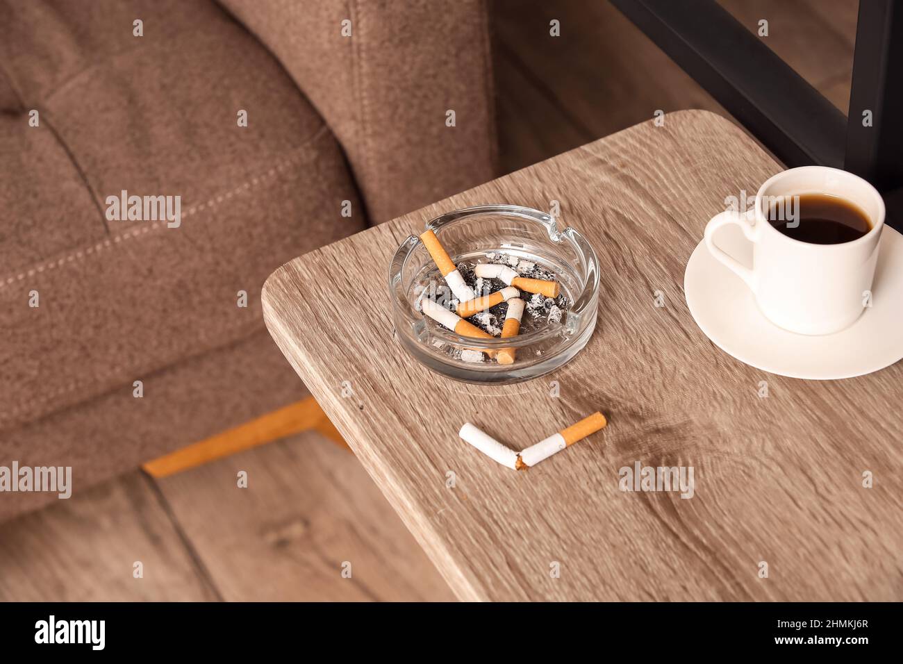 Ash tray with cigarettes and cup of coffee on table Stock Photo