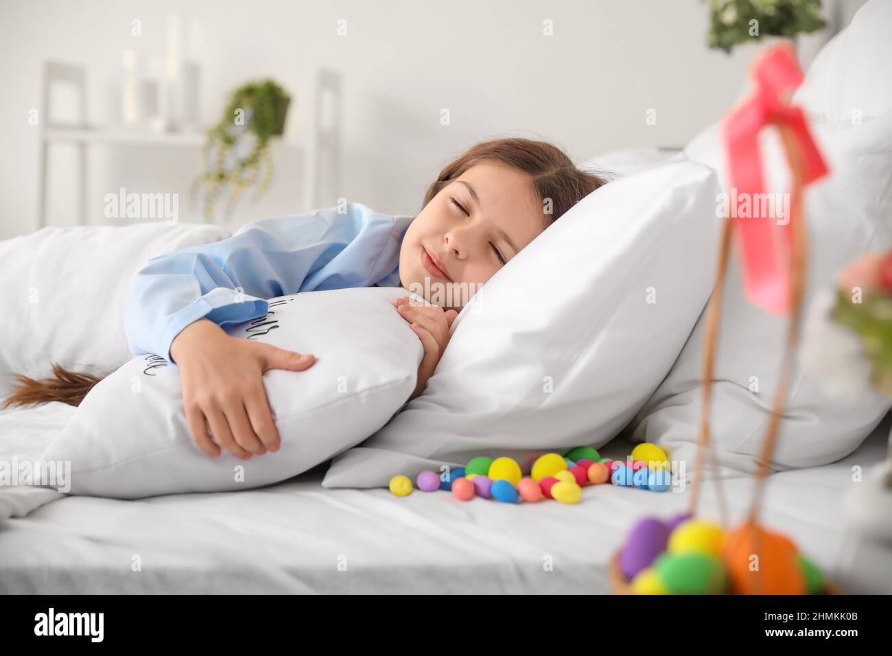 Cute little girl in bed with Easter eggs under pillow Stock Photo Alamy