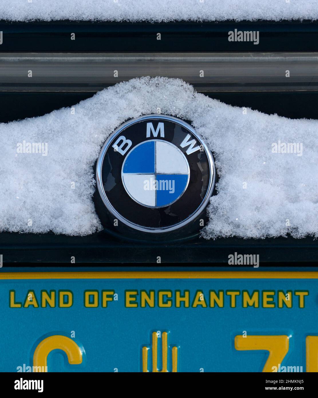 The BMW logo on the back of a parked car after a snowstorm in Santa Fe, New Mexico. Stock Photo