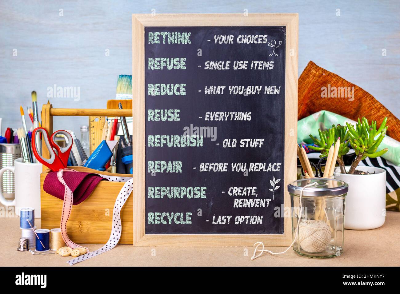 R's of sustainable waste management on chalkboard placed on workshop bench with tools and materials for repair, repurpose, refurbish Stock Photo