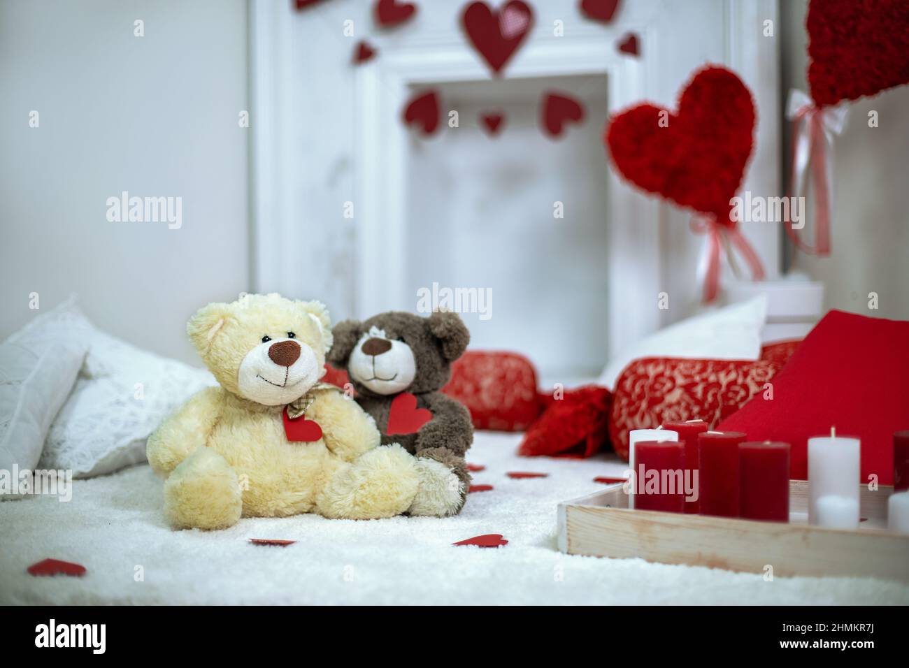 Romantic setting. Two cozy toys bears with hearts. Candles burning Stock Photo