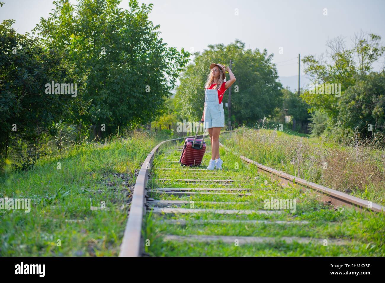 a man is walking on the railroad with a suitcase Stock Photo