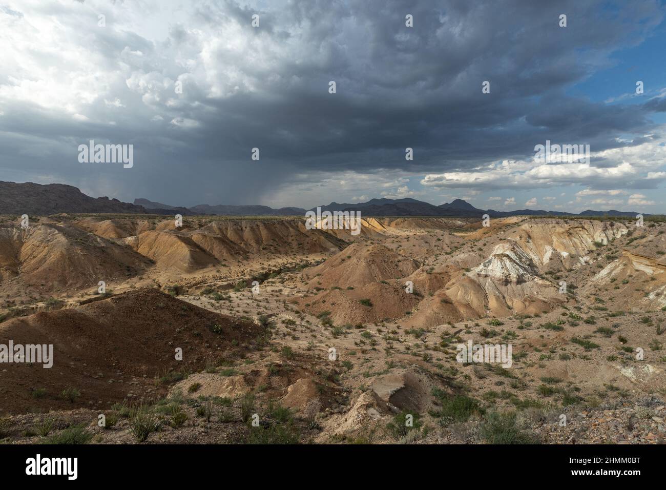 During the summer monsoon, thunderstorms drench a small area of the desert. Runoff erodes the Cretaceous rock formations to create badlands. Stock Photo