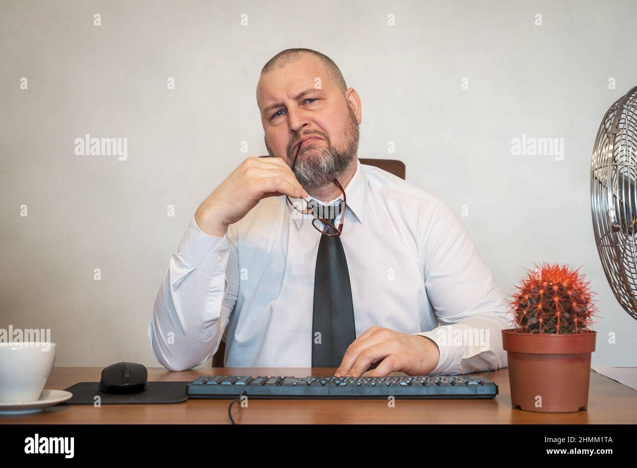 The man comically portrays the work of a businessman. He shows displeasure on his face and posture. Stock Photo