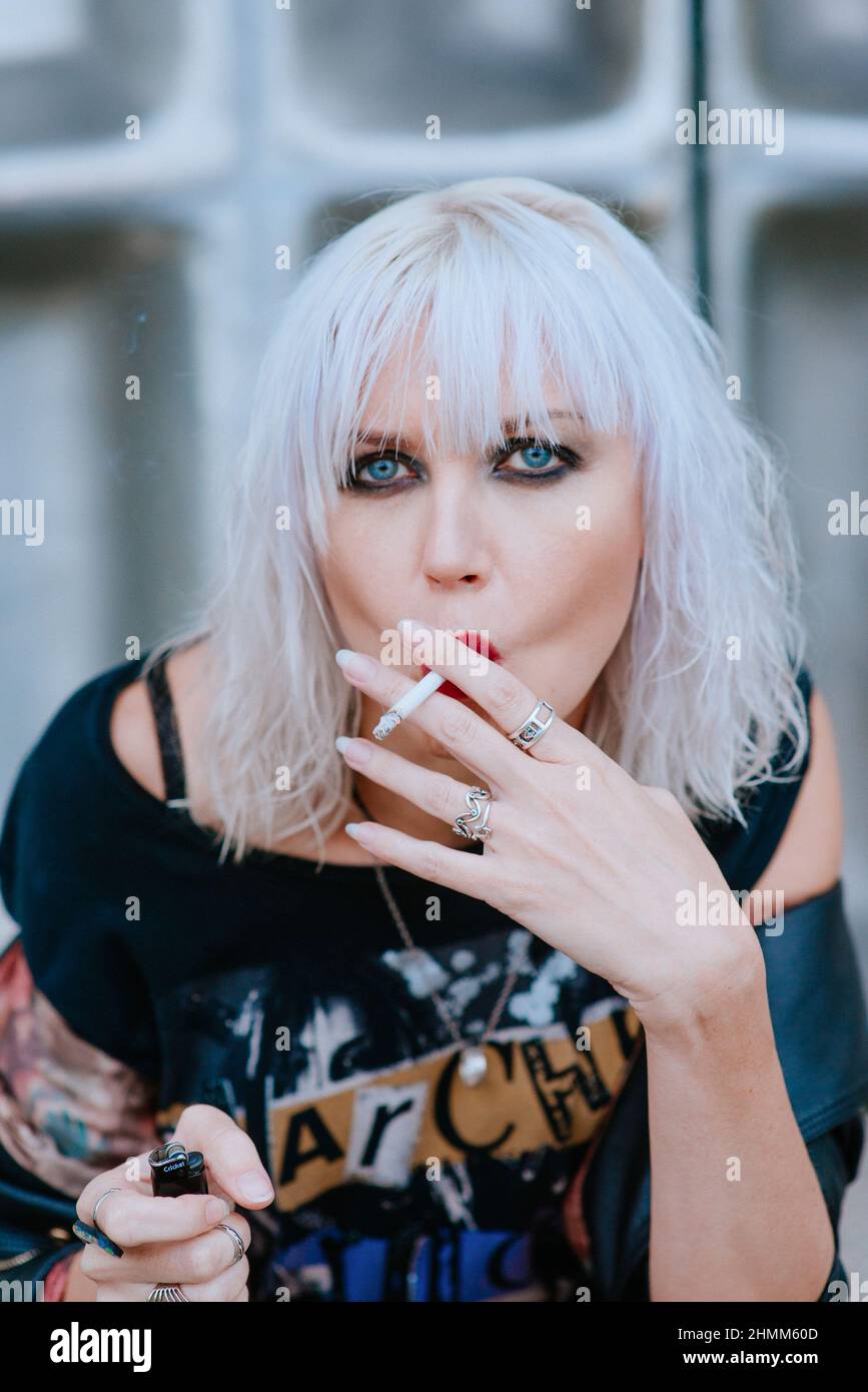 Portrait of stylish blonde grunge young woman with make up smoking cigarette Stock Photo