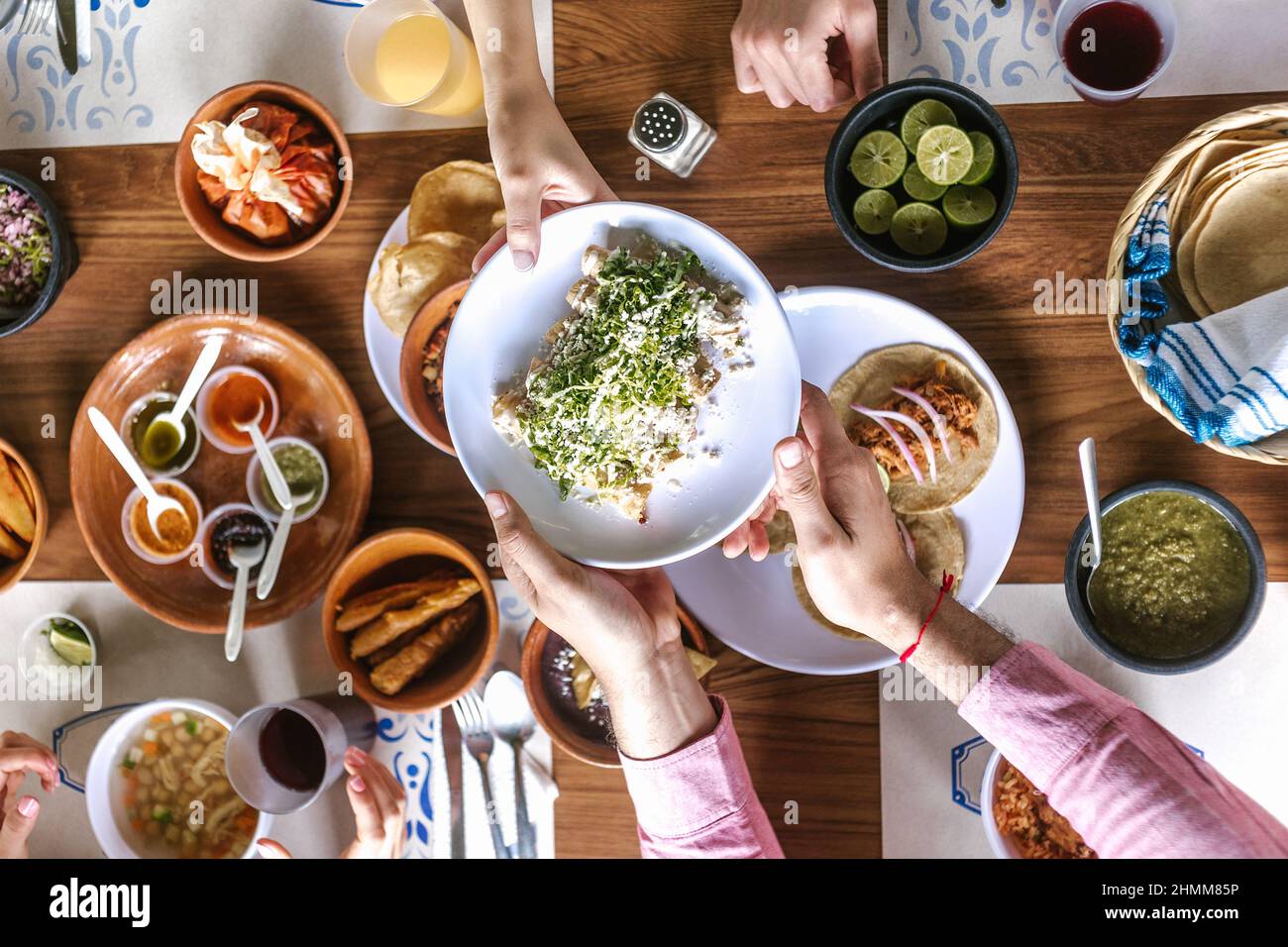 group of latin Friends eating Mexican Tacos and traditional food, snacks and peoples hands over table, top view. Mexican cuisine Latin America Stock Photo