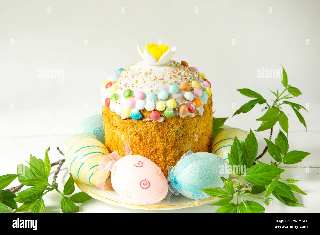 Easter cake with painted eggs on a platter in a gray interior. Traditional festive food Stock Photo