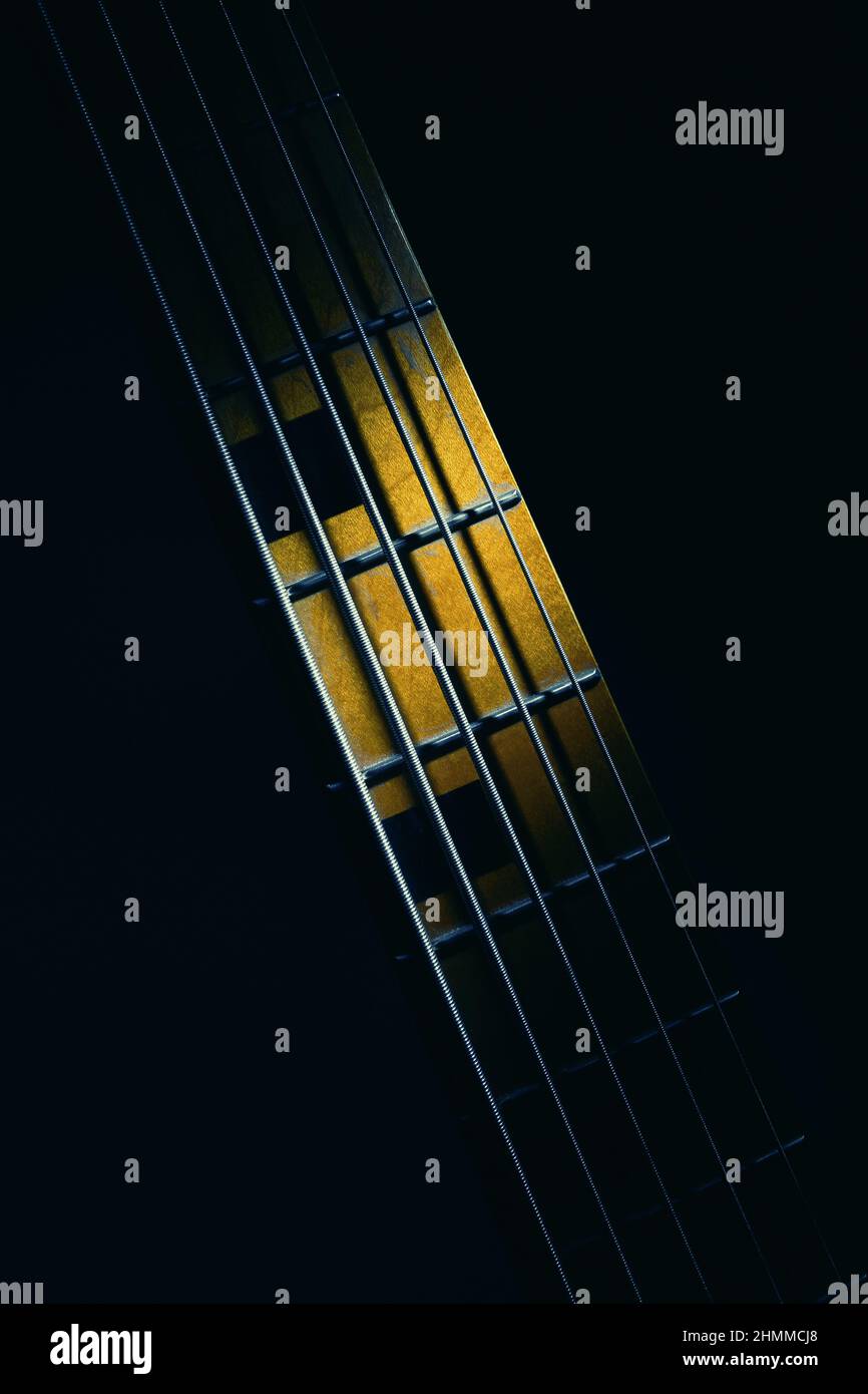 Closeup view of neck of five strings bass guitar, highlighted shapes. Stock Photo