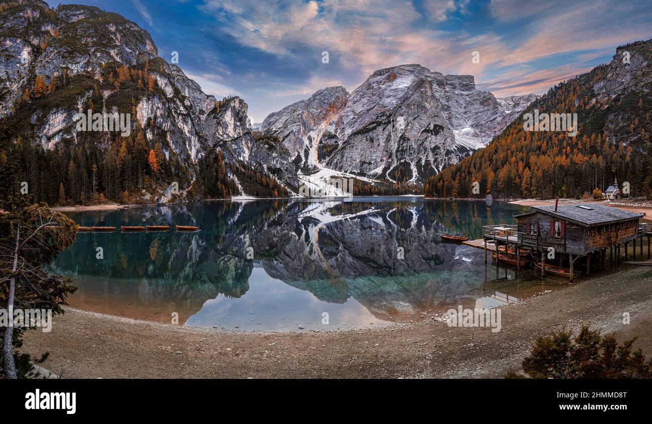 Lake Braies, Italy - Beautiful autumn sunrise at Lake Braies (Lago di Braies) in the Italian Dolomites at South Tyrol with wooden boats, wooden cabin Stock Photo