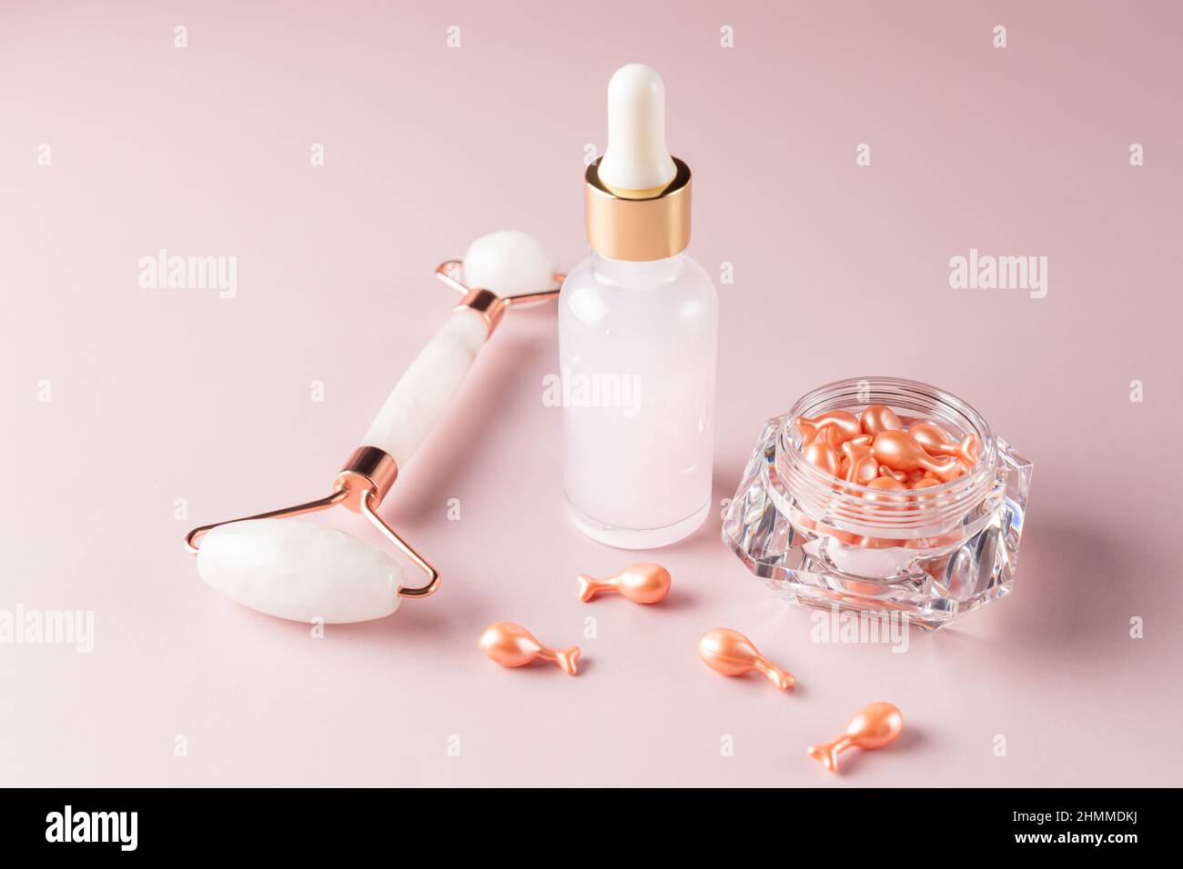 beauty treatment cosmetic set for dayl skin care routine. Single dose serum capsules. brauty oil in dropper bottle and rose quartz massage roller on p Stock Photo