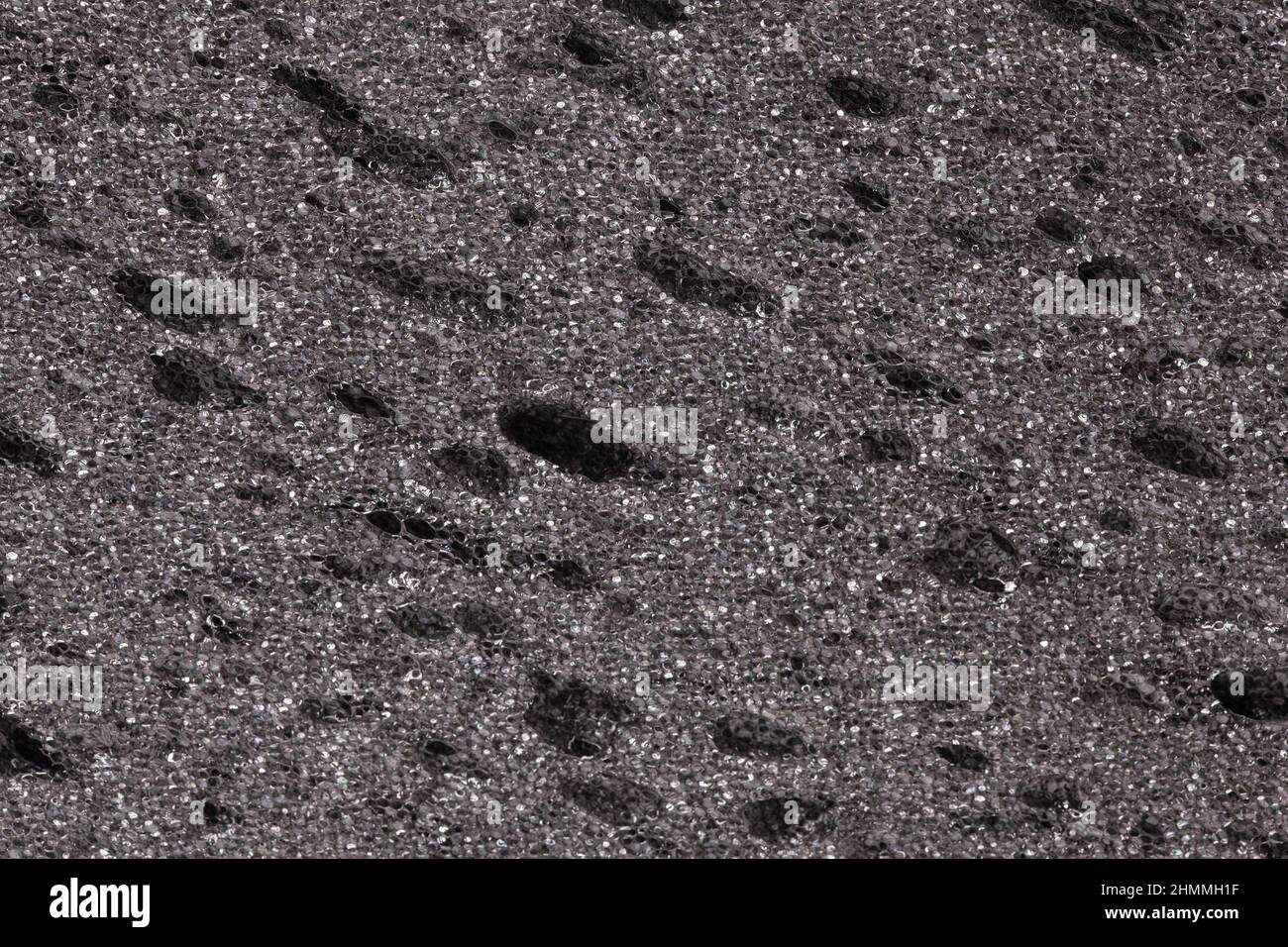 Black grey sponge textured background. Foam rubber background. Stock Photo