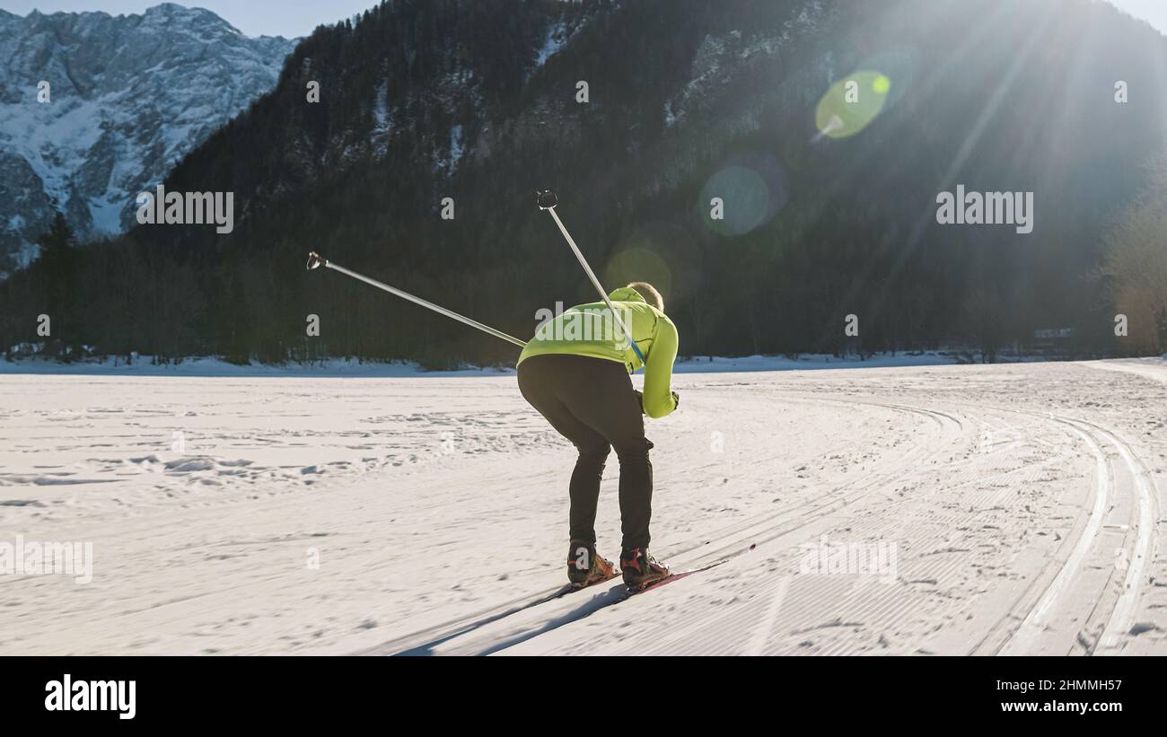 Man performing cross country downhill skiing technique, in the squat position and folded the