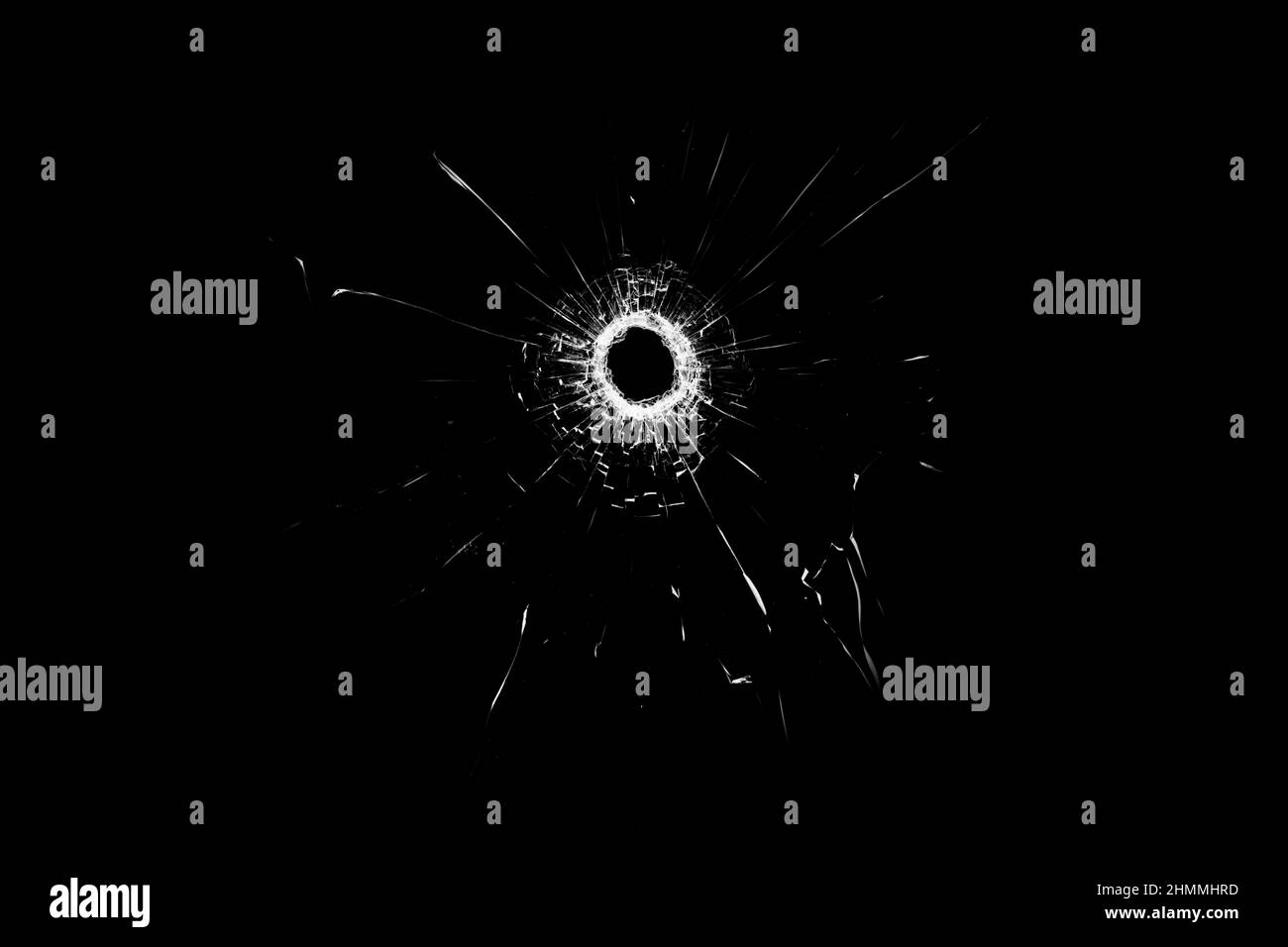 Texture of broken glass. Hole from a ball on a black background. Stock Photo