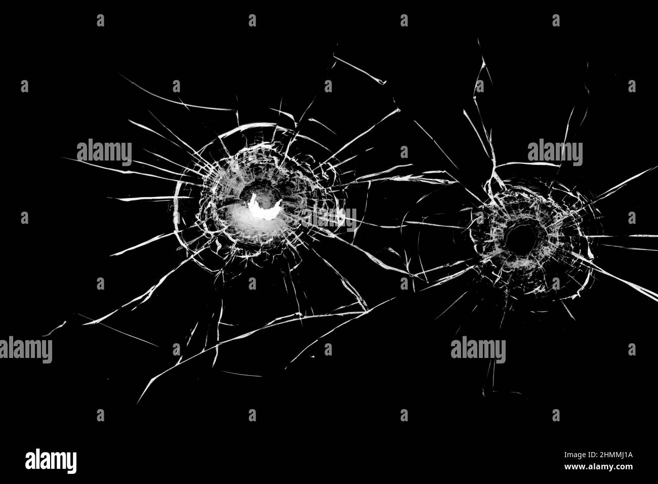 Texture of broken glass. Hole from a ball on a black background. Stock Photo