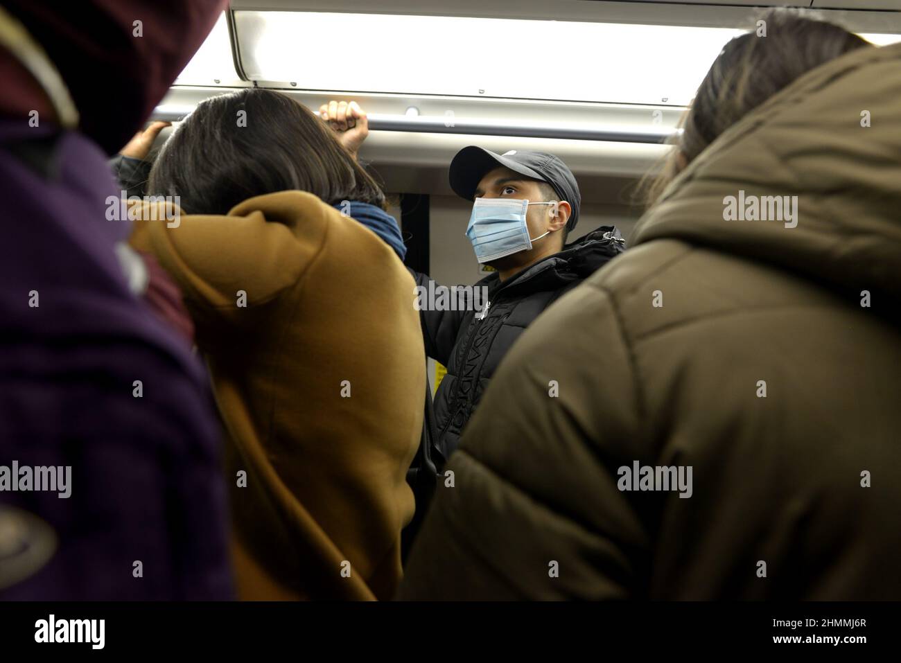 London, England, UK. London Underground: man wearing a COVID face mask on a crowded tube train. Jan 2022 Stock Photo