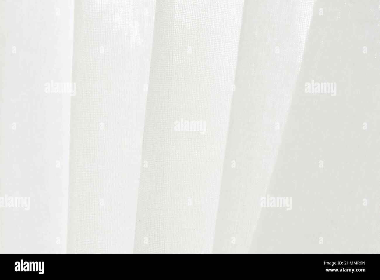 Close up white linen curtain background texture hanging by the window ...