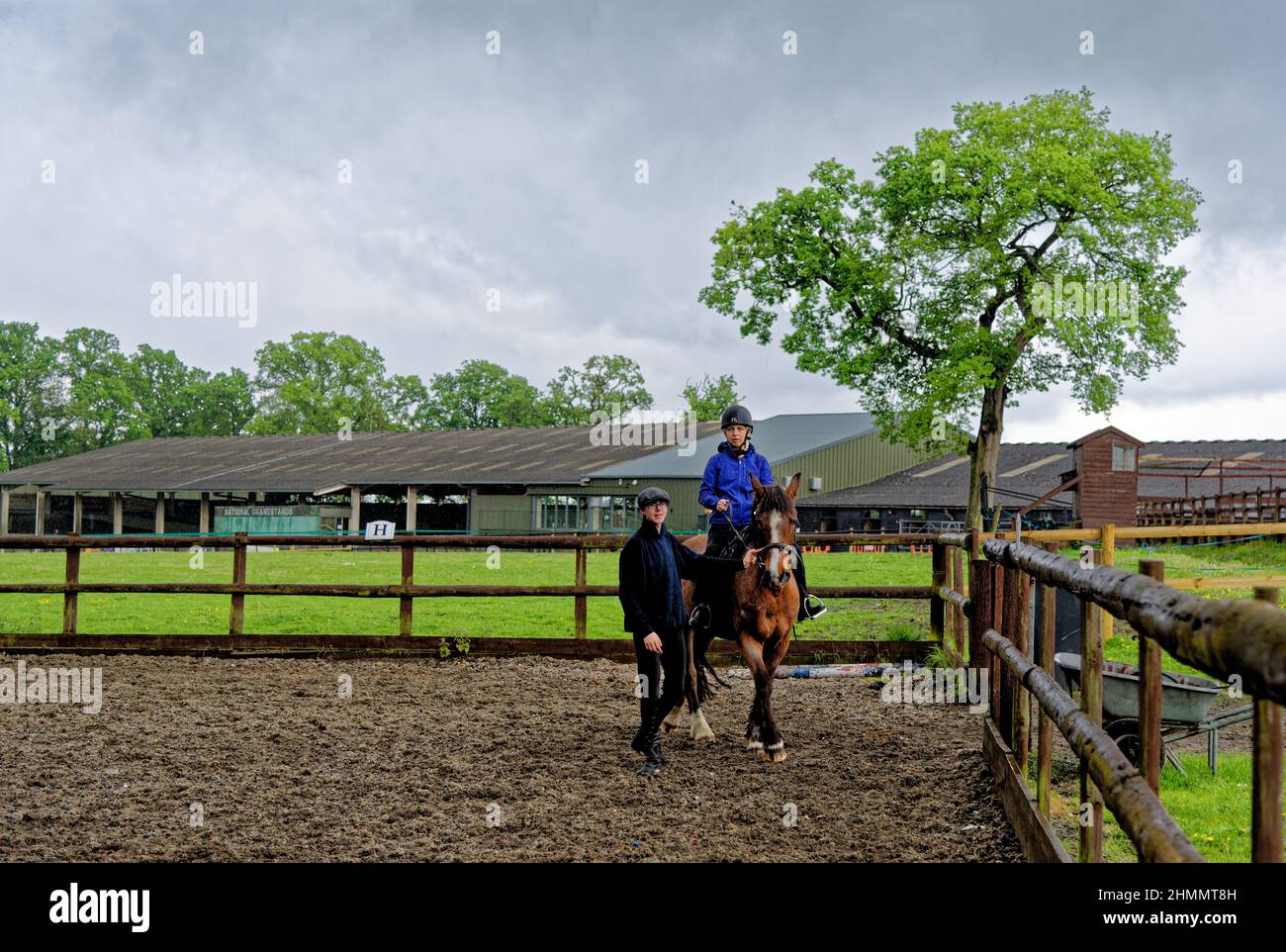 Girl having her first horse riding lesson bareback with hard hat helmet and instructor. Wellington Riding School, Hook, United Kingdom. 11.05.2016 Stock Photo