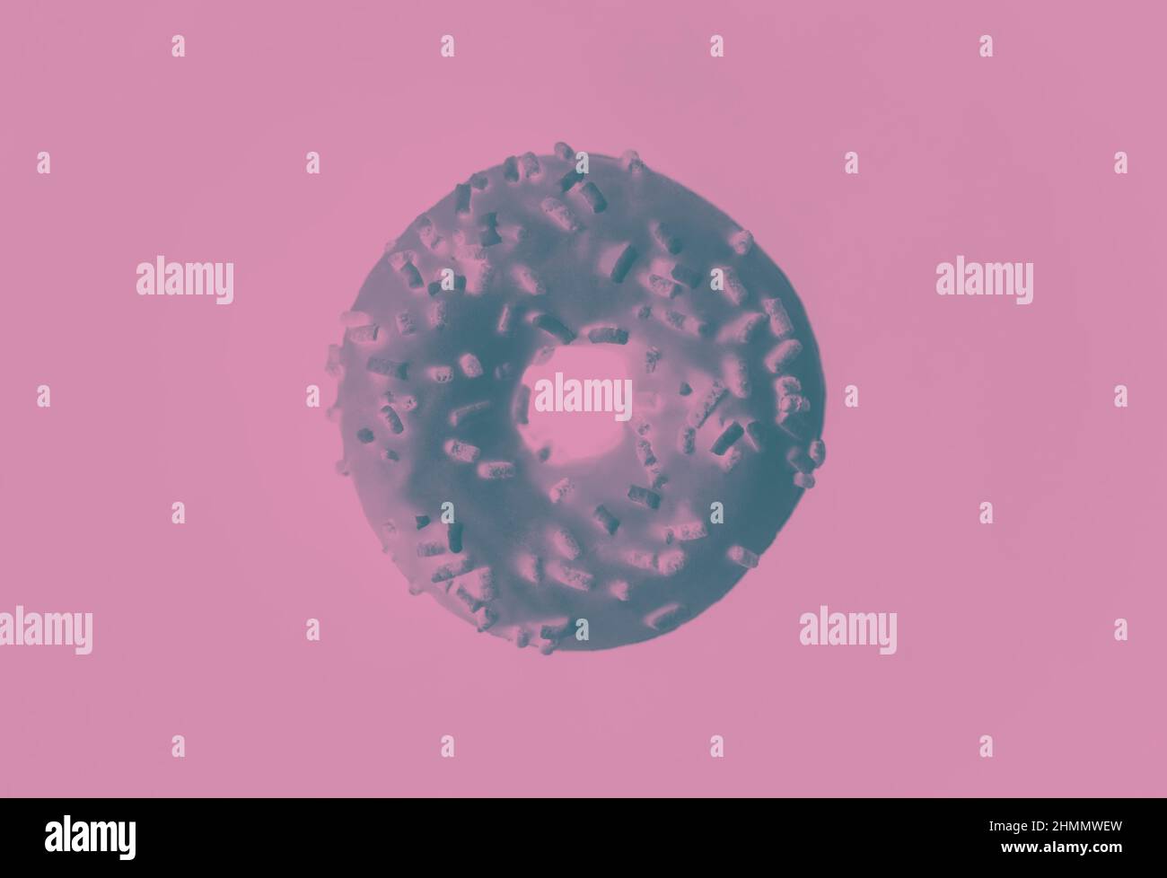 One sweet donut with sprinkles on a pink background with a negative filter. The donut symbol. Sweet delicious pastries. Stock Photo