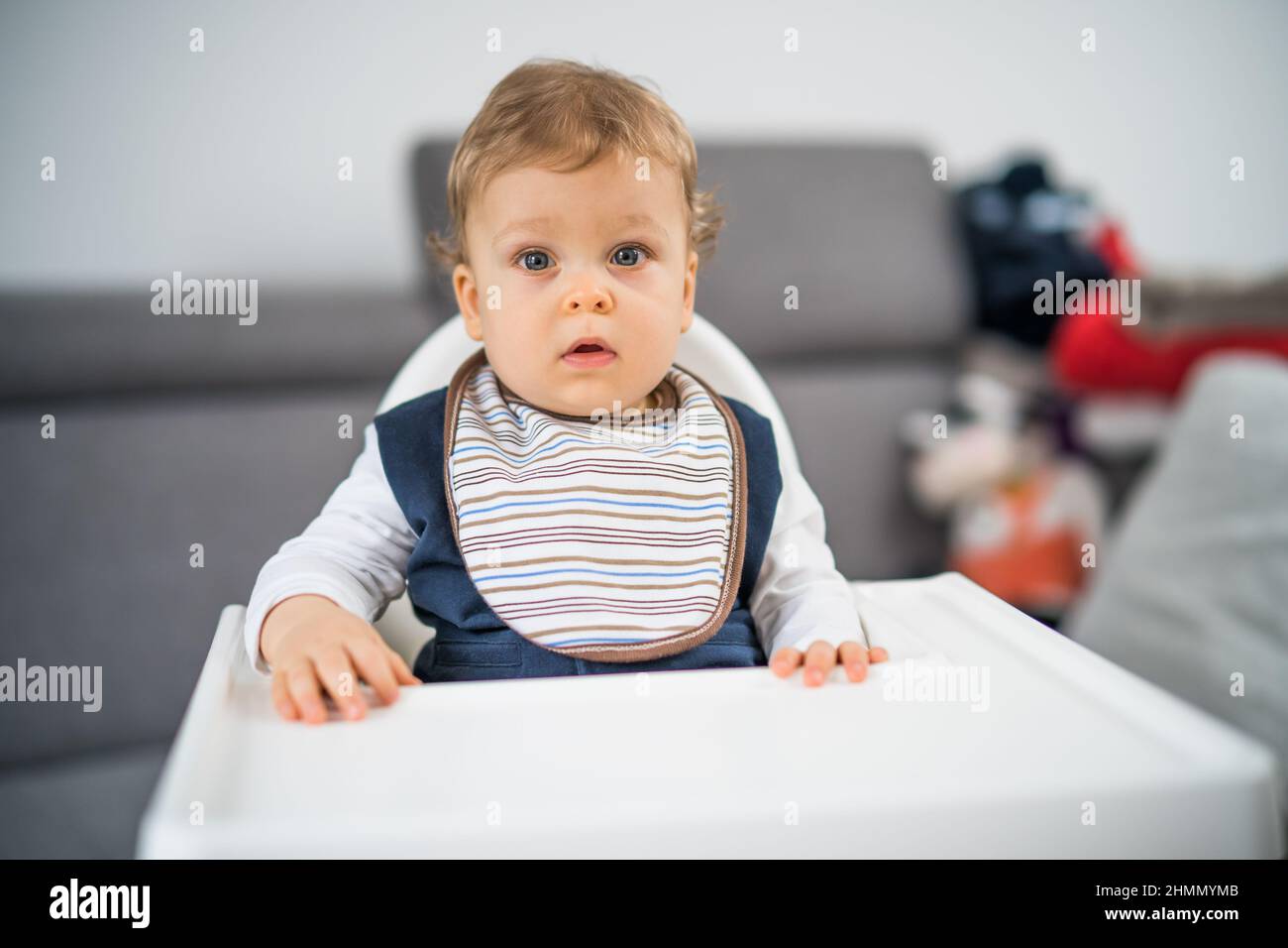 Portrait of cute baby boy sitting in a high chair Stock Photo Alamy