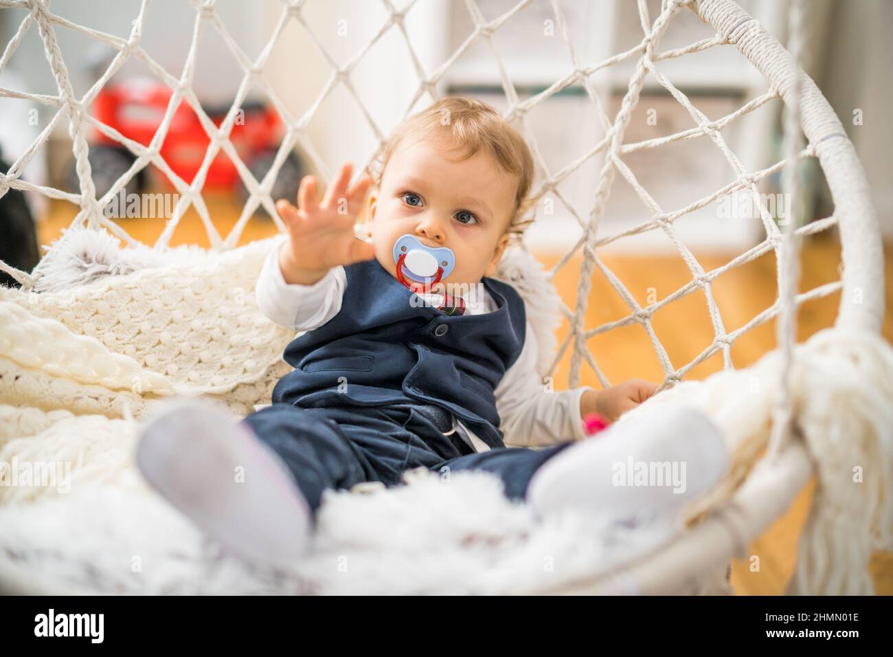 Image of cute baby boy with pacifier sitting . Stock Photo