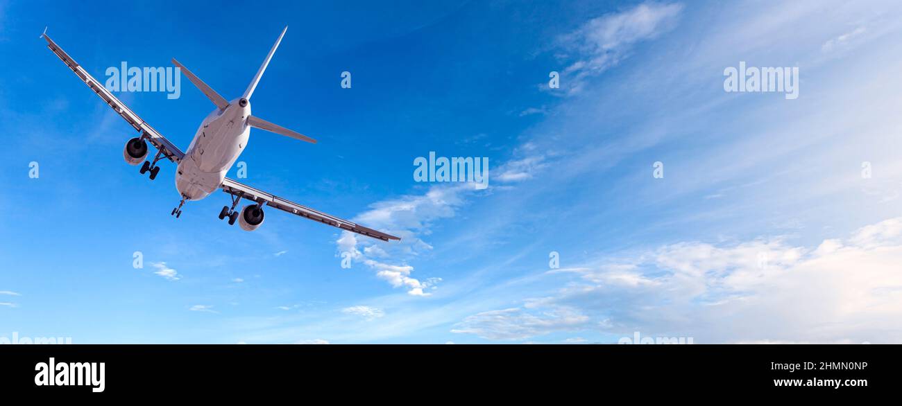Airplane taking off on blue sky background Stock Photo - Alamy