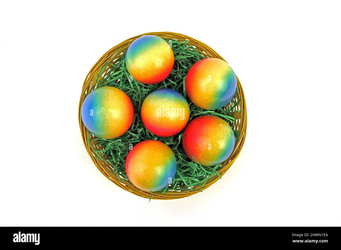 decorated brightly colored Easter eggs in a basket, view from above Stock Photo