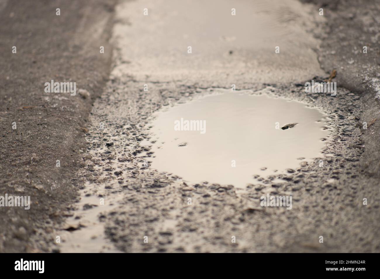 Close up puddle on a wet asphalt road. Stock Photo