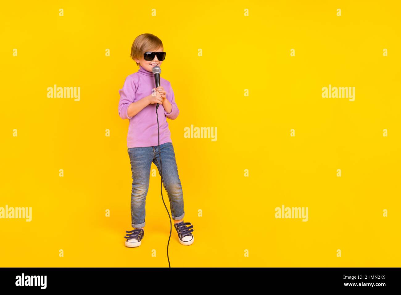 Full size photo of cheerful funny little guy future famous singer hold mic  singing song isolated on yellow color background Stock Photo - Alamy