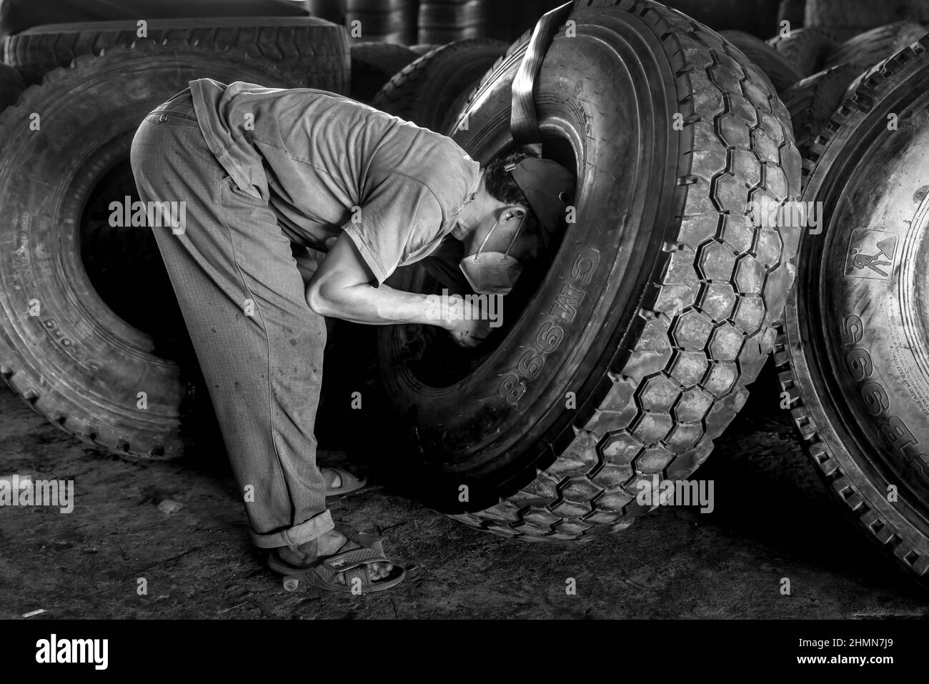 Son Tinh, Quang Ngai, Vietnam - December 31, 2021: workers work at an old car tire recycling factory in Son Tinh district, Quang Ngai province, Vietna Stock Photo