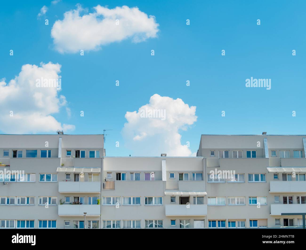 front view of modern apartment building against blue sky in a sunny day ...