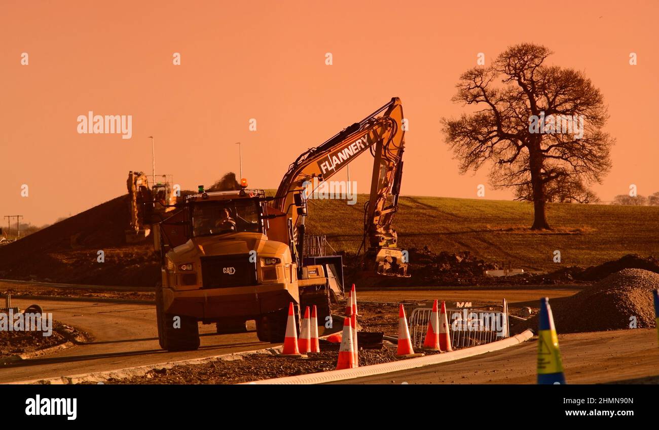 heavy earth moving machinery building Leeds Orbital road at sunset