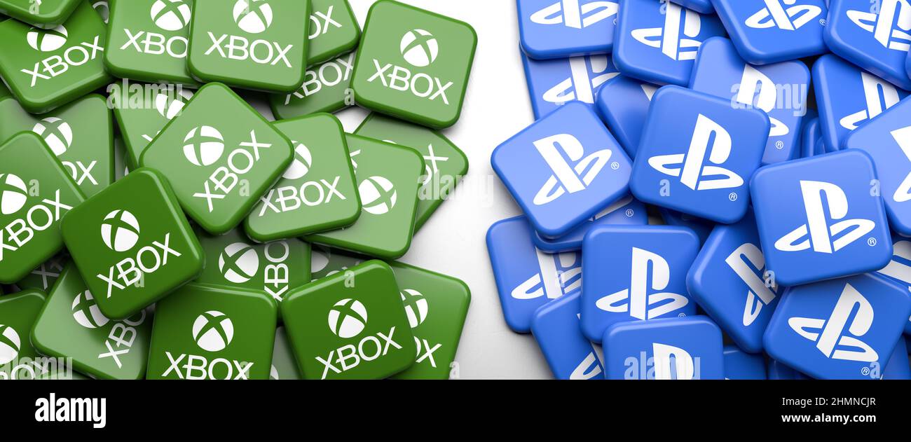 Logos of the competing home video game console systems Sony PlayStation and Microsoft X-Box on a heap on a table. Web banner format. Stock Photo