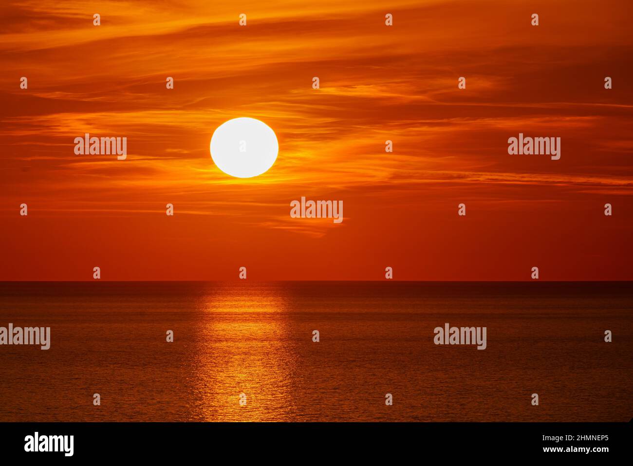 Fantastic sunset over ocean. The sun goes down over the sea. Dramatic Sunset Sky Stock Photo