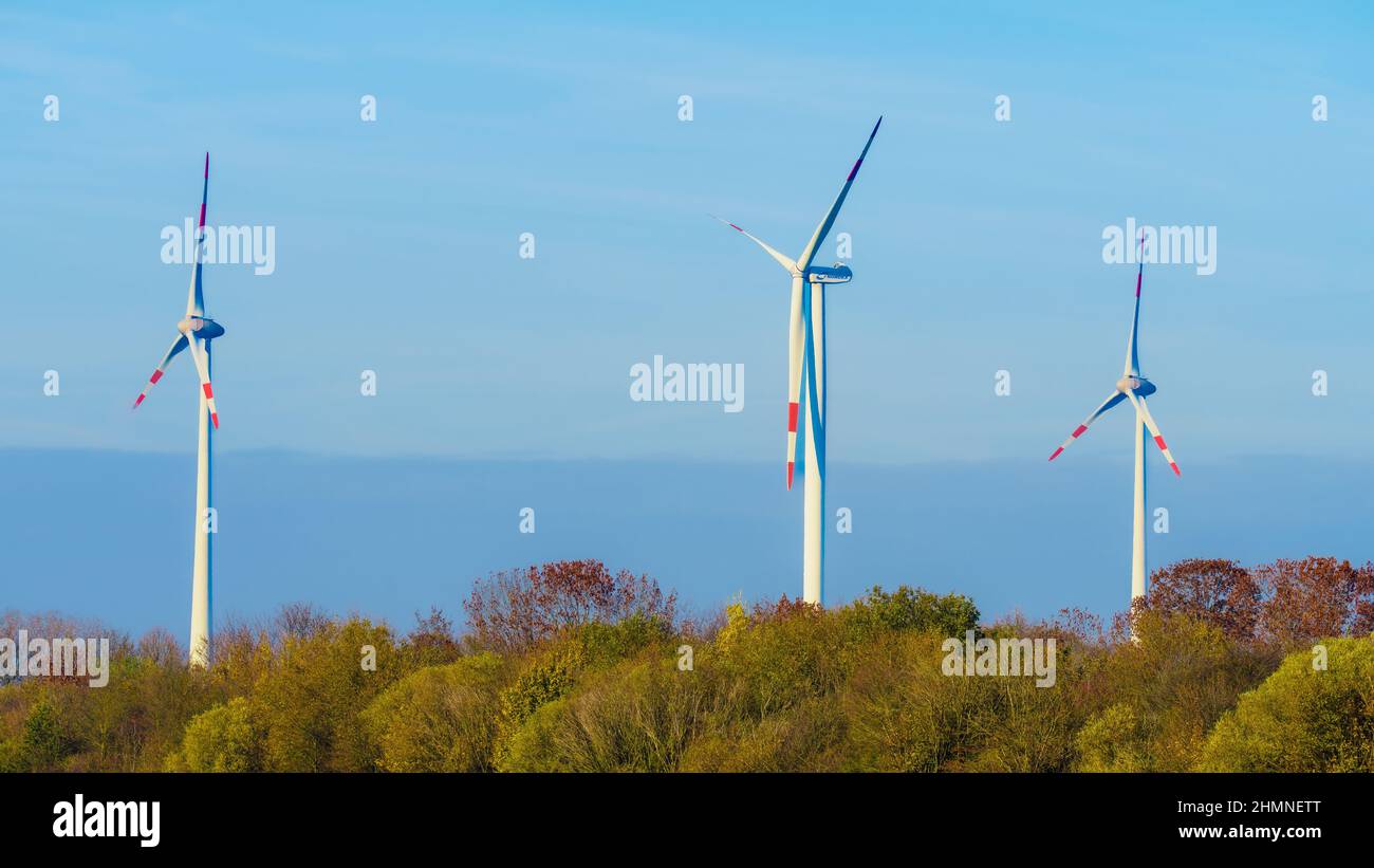 Windmills wind turbines farm power generators. Production of renewable green energy Stock Photo