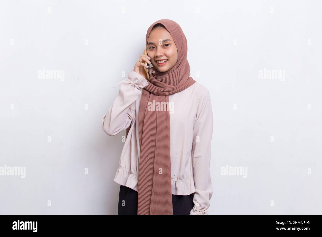 happy young asian beautiful muslim woman using mobile phone isolated on ...