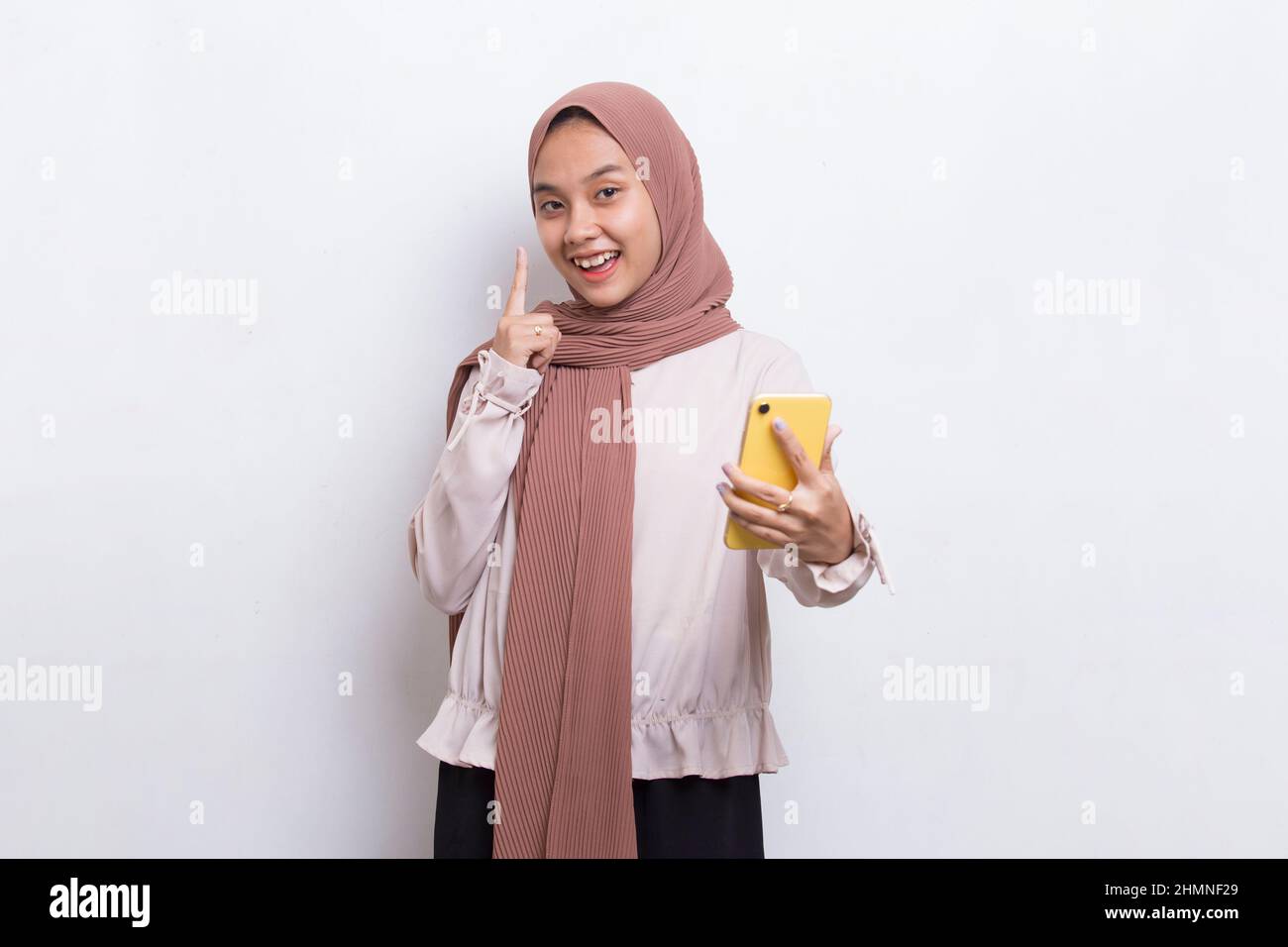 happy young asian beautiful muslim woman using mobile phone isolated on ...