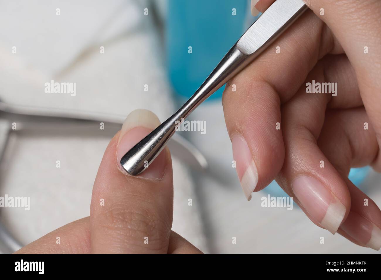 Manicure. Push back the cuticle with a metal pusher. Getting injured