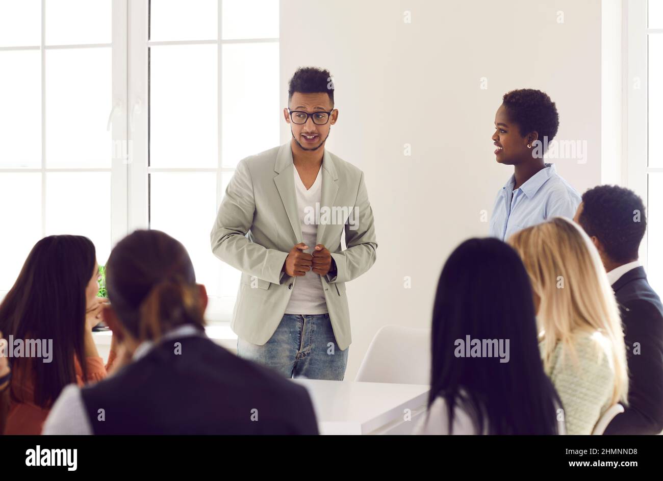 Young business team manager talking to his diverse employees during a work meeting Stock Photo