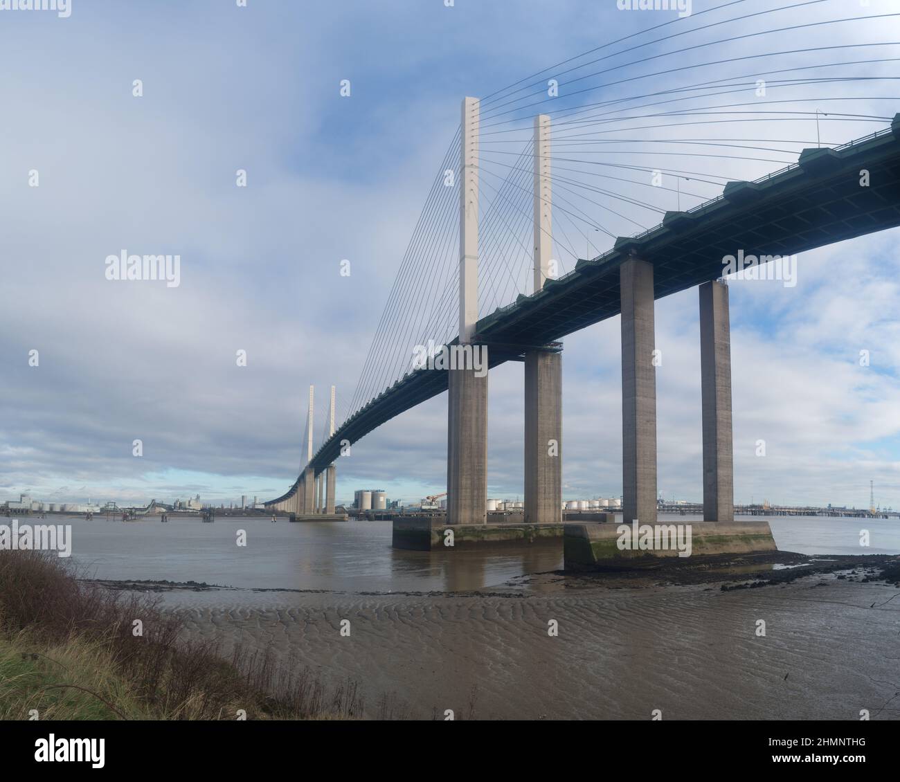 Dartford river crossing at low tide showing silt and mud deposits on river banks with Fucus vesiculosus bladderwrack on holdfast on higher rocks Stock Photo