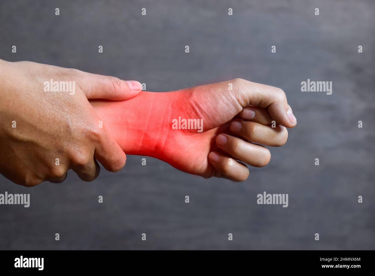 Inflammation of Asian young man wrist joint and hand. Concept of joint pain and hand problems