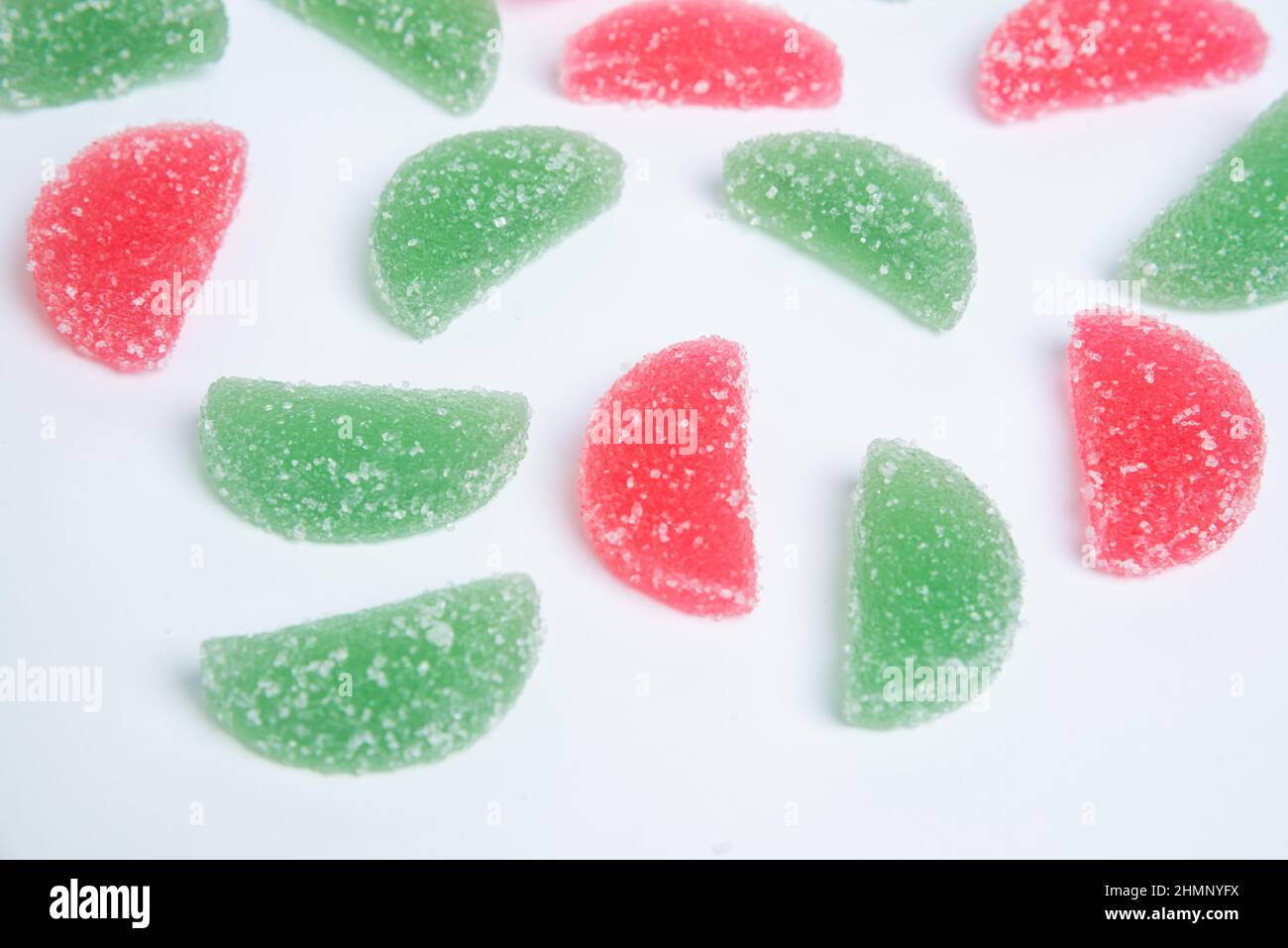 Sweet pattern, marmalade jelly candies of different colors on a white background with sugar crystals. Stock Photo
