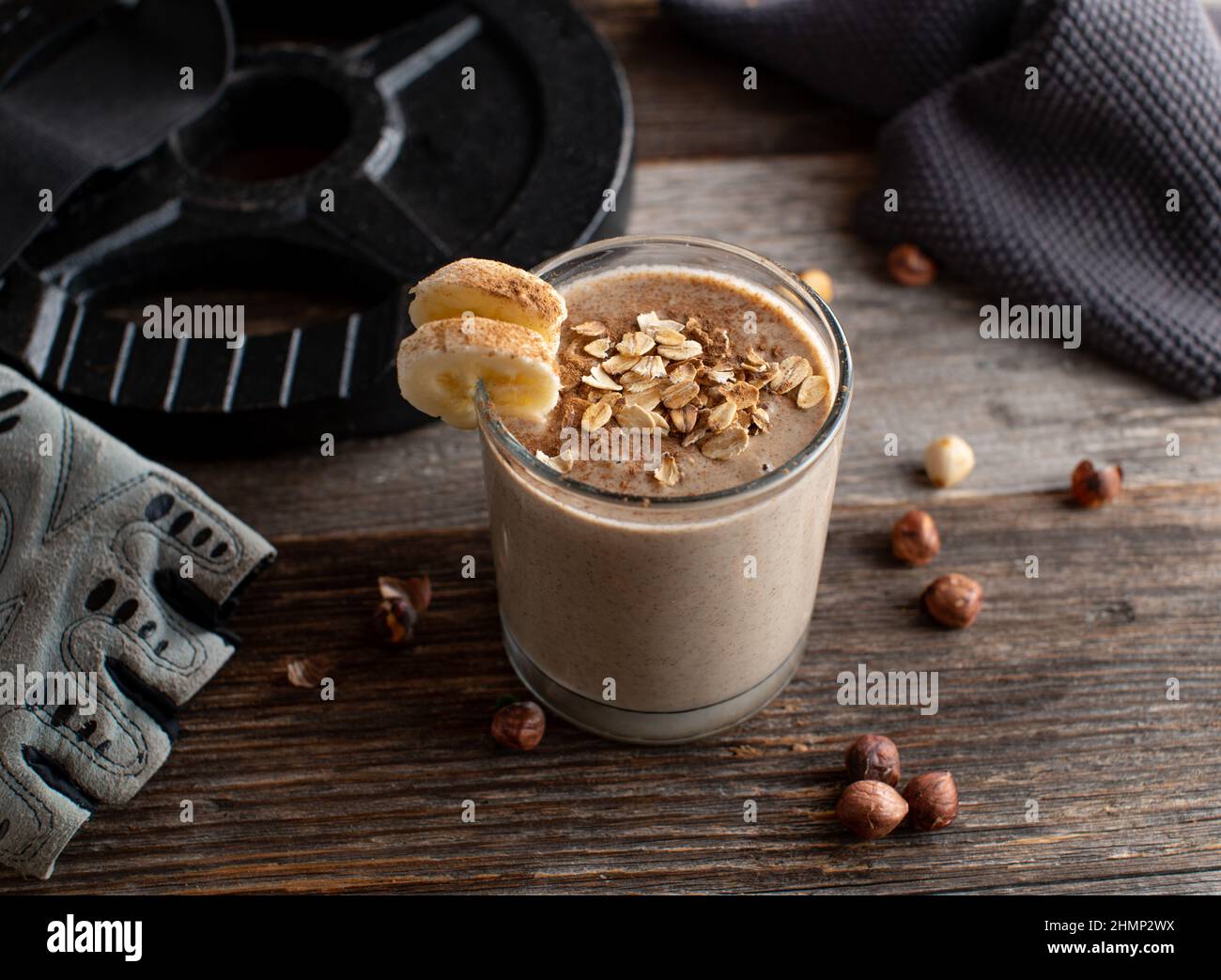 Body building snack for muscle gain. Pre workout shake with chocolate whey protein, oat flakes, bananas and hazelnuts Stock Photo