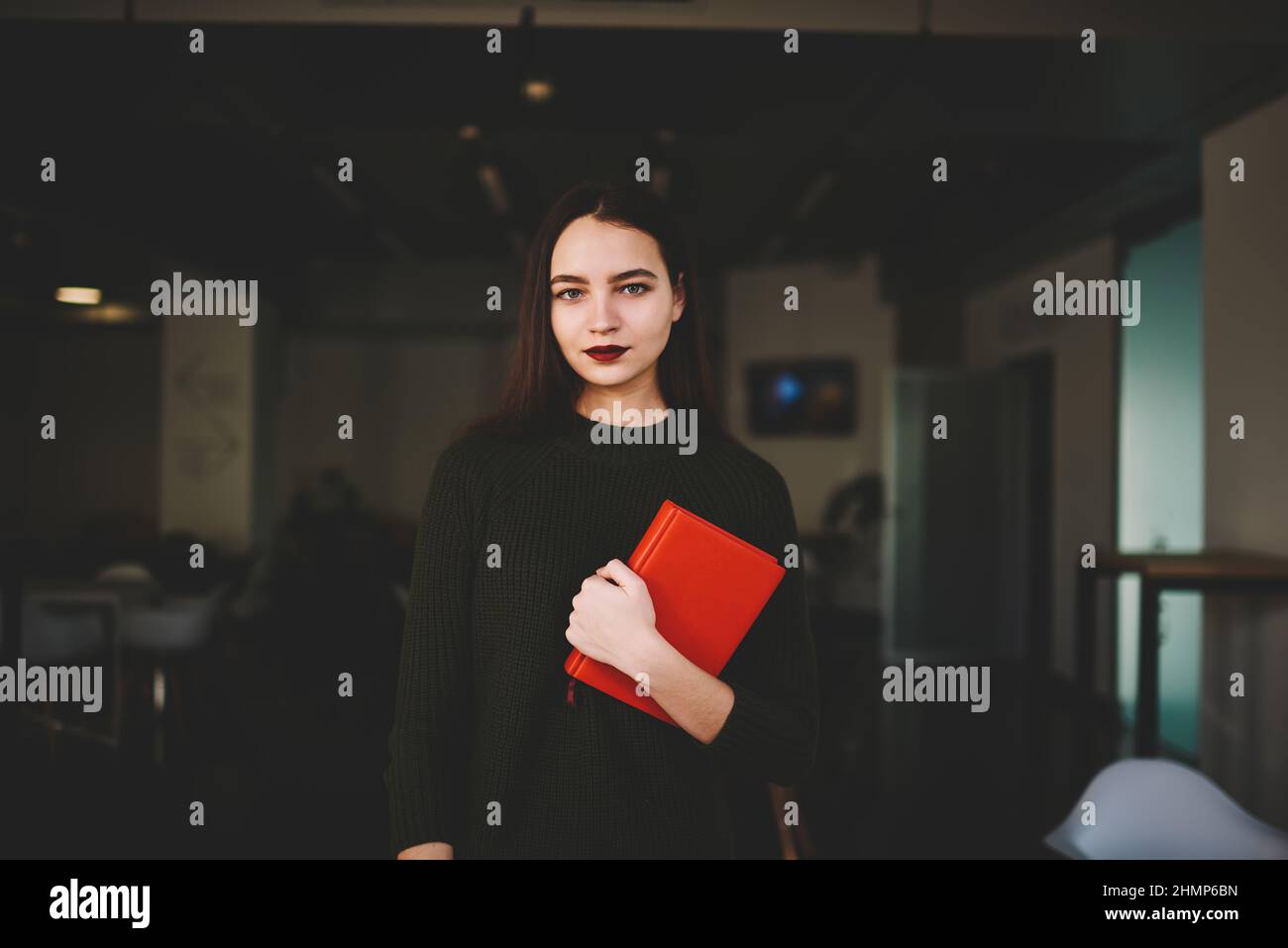 Charming woman with red notebook in cafe Stock Photo