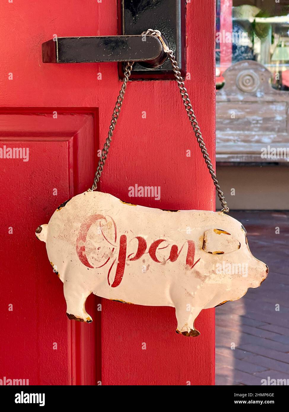 vintage pig shaped metal 'Open' sign hanging from door knob Stock Photo