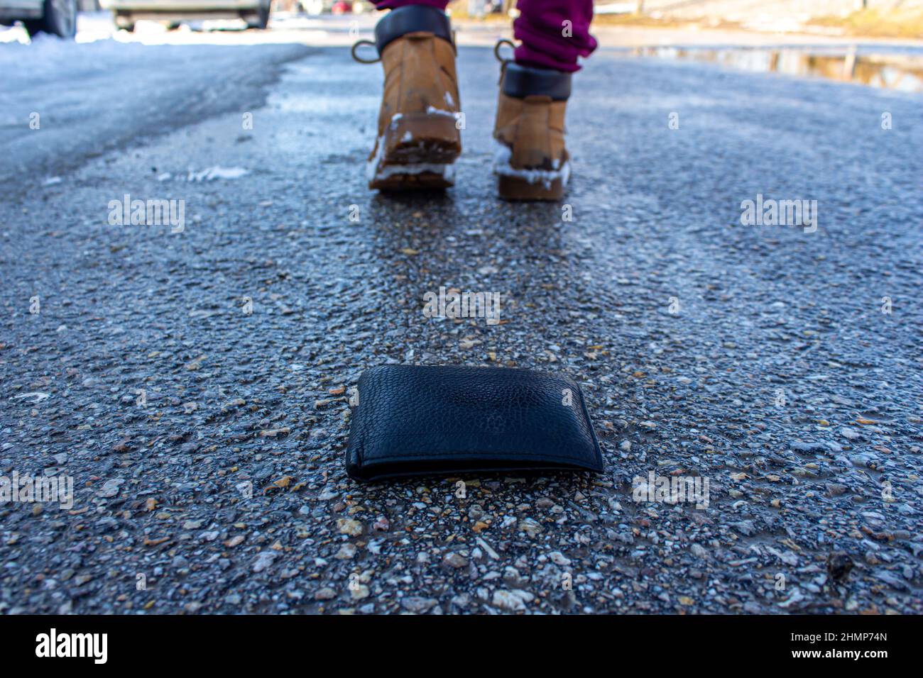 Man dropping his wallet on the road. Concept of losing wallet. Stock Photo