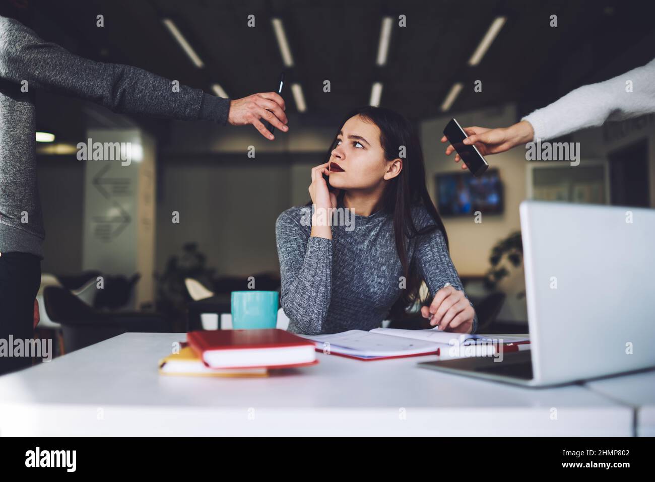 Busy assistant speaking on mobile phone in office Stock Photo