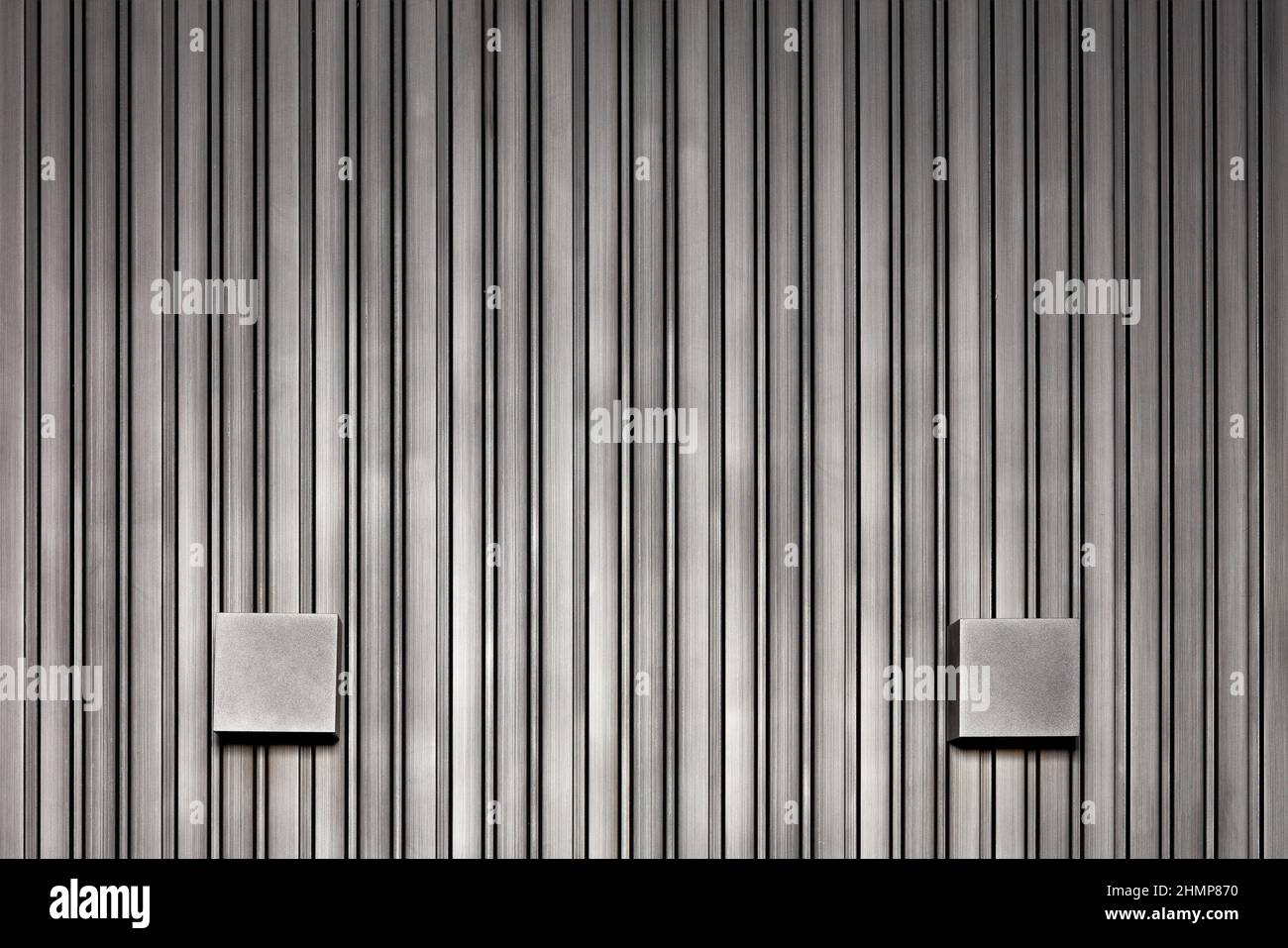 Silver and black wooden wall with vertical rails and symmetrical square